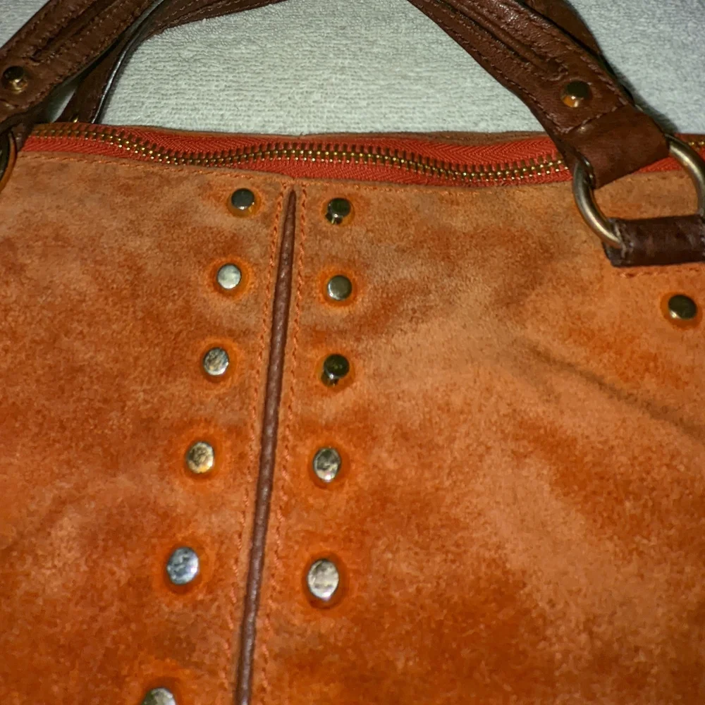 Michael Kors orange suede studded slouchy shoulder bag.